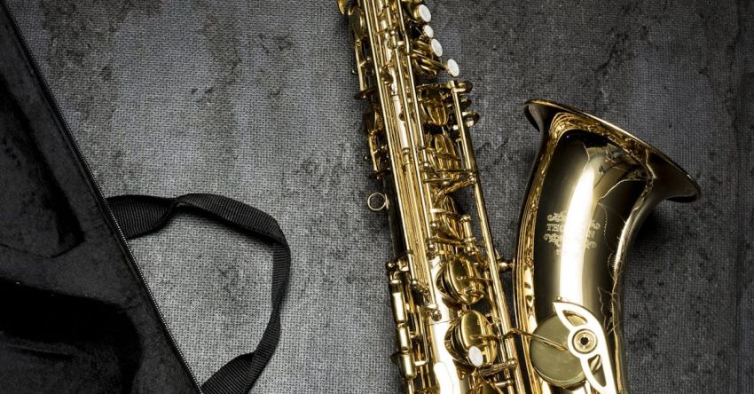 Musical Instrument - Brass Saxophone on Gray Table Near Black Bag