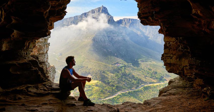 Caves - Photo of Man Sitting on a Cave