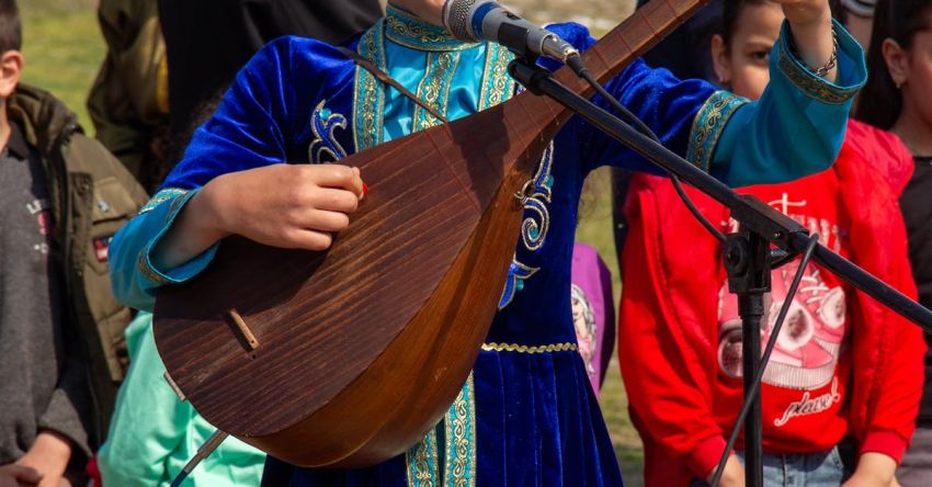 Music Festivals - A young boy playing a musical instrument in front of a crowd