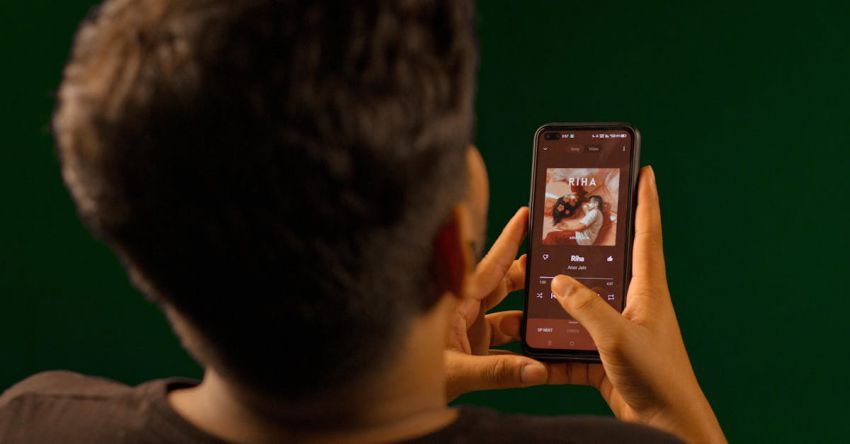 Streaming Service - Back View of a Man Playing Music on His Phone